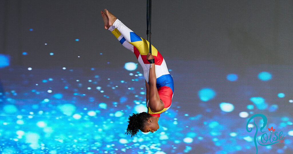 Performance artist hanging upside down from the ceiling
