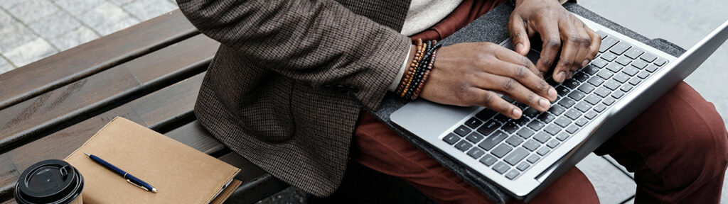 Smartly dressed man sitting down with a laptop on his knee